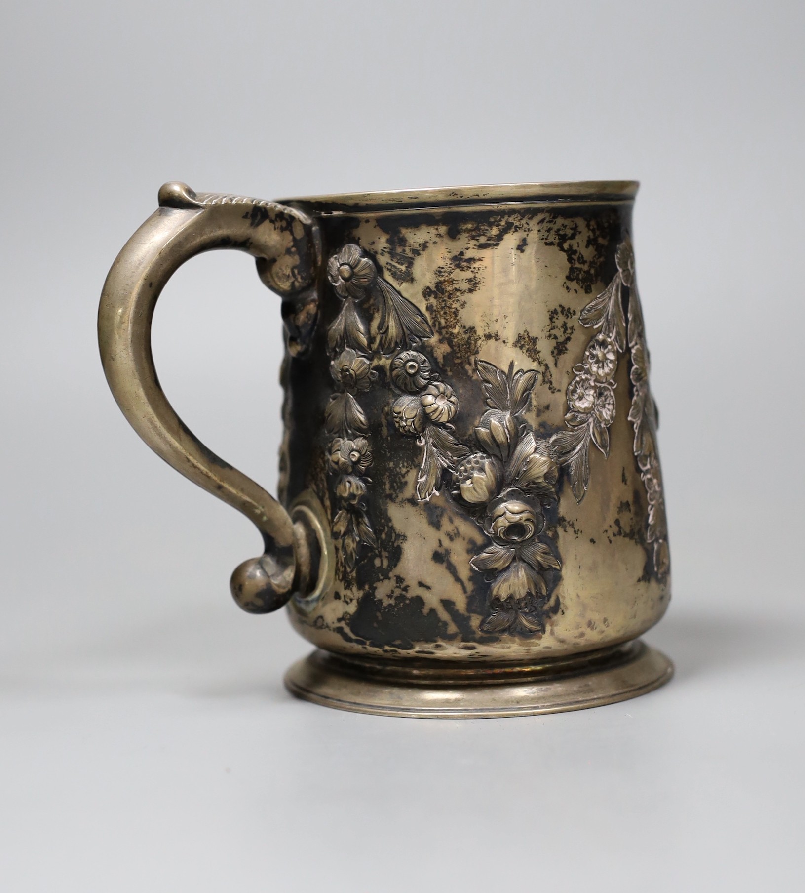 A George III silver pint mug, with later Victorian embossed and chased floral swag decoration and 1862 Agricultural Prize inscription, London 1753, 11 oz.